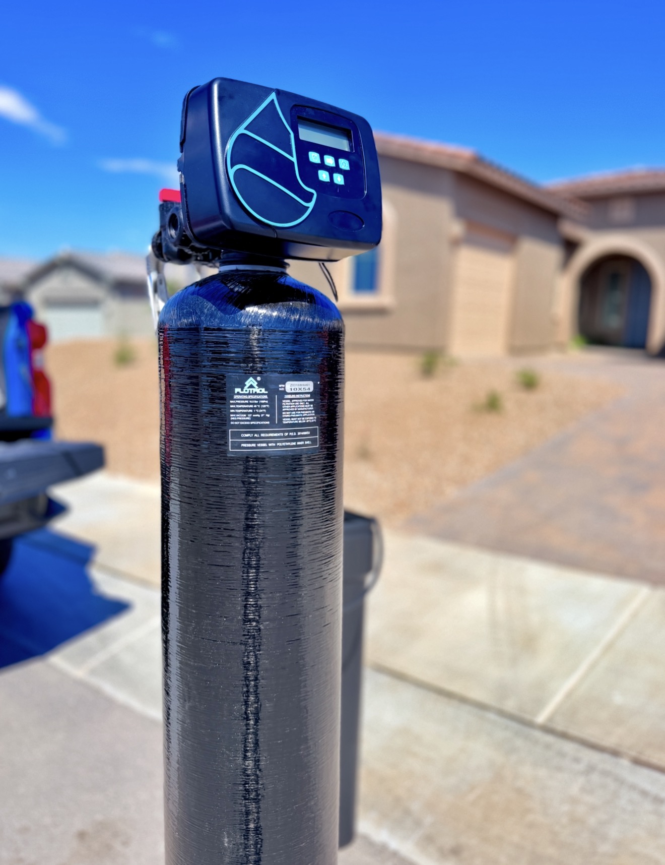 Close-up of an Aqua Soft water softener and digital control valve outside an Arizona home